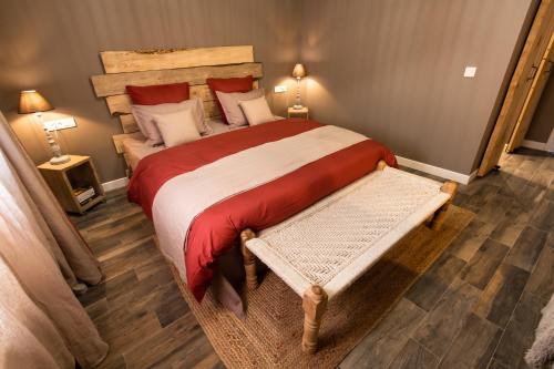 a bedroom with a large bed with a red blanket at J&J Room - Hébergement d'exception prés de Provins! in Le Bas Courton