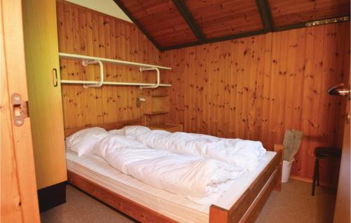 Cama en habitación con pared de madera en 3 Bedroom Pet Friendly Home In Blvand, en Blåvand