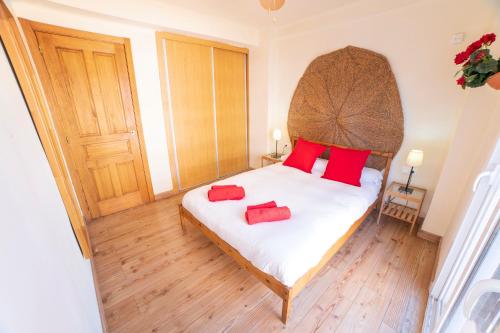 a bedroom with a bed with two red pillows on it at CITY CENTER NEXT TO THE BEACH 2 BEDROOMs APARTMENT in Málaga