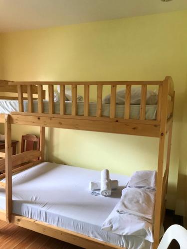 een slaapkamer met 2 stapelbedden met witte lakens bij Jhunlyn Room Rental in Tagaytay