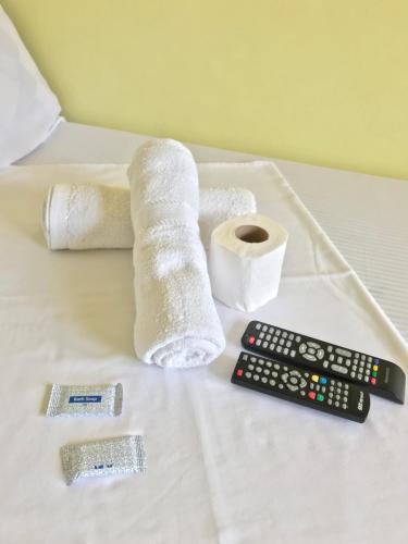 a pile of toilet paper and a remote control on a bed at Jhunlyn Rooms for Rent Tagaytay in Tagaytay