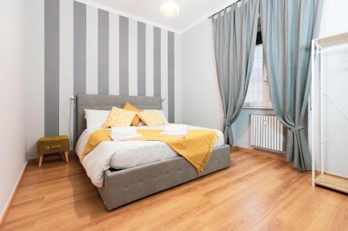 ein Schlafzimmer mit einem Bett mit gestreifter Wand in der Unterkunft Relais Mantellini in Rom