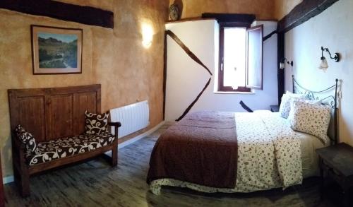 a bedroom with a bed and a chair at EL CAMPANARIO in Guinicio