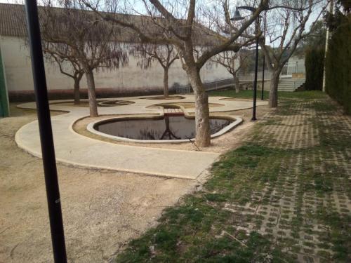 un parque con un banco y árboles en un parque en DELICIAS, en Peraltilla