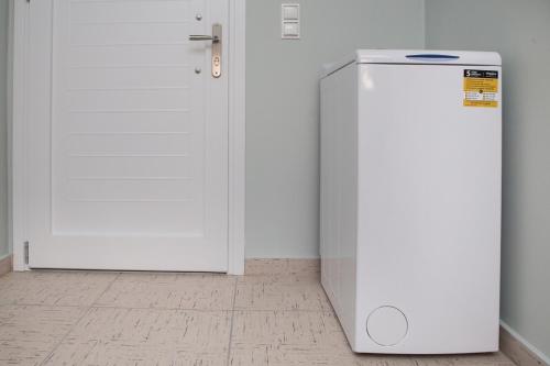 a white refrigerator next to a white door in a room at Manolatos Apartment Kefalonia in Lixouri