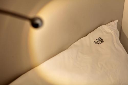 a white pillow with a sticker on it next to a lamp at Albergo Accademia in Trento
