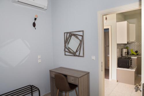a white room with a desk and a kitchen at Manolatos Apartment Kefalonia in Lixouri