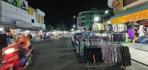 a man riding a motorcycle past a market at night at NHÀ NGHỈ VIỆT NGA in Ha Tien