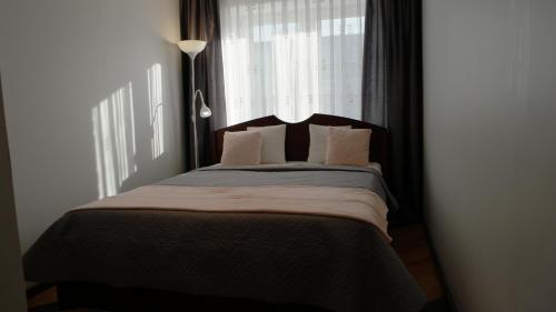 um quarto com uma cama grande e uma janela em Dange apartment em Siauliai