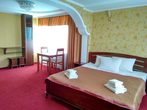 ein Hotelzimmer mit einem Bett mit Handtüchern darauf in der Unterkunft Tourist Poltava in Poltawa