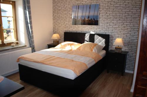 a bedroom with a large bed with a brick wall at Meine Fischerhütte in Börgerende-Rethwisch