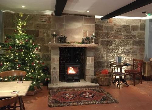 a living room with a christmas tree and a fireplace at The White Hart Apartment Valley View in Alton
