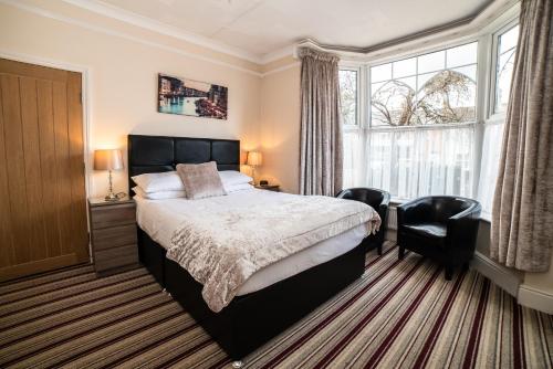 1 dormitorio con 1 cama, 2 sillas y ventana en The Causeway Guest House en March