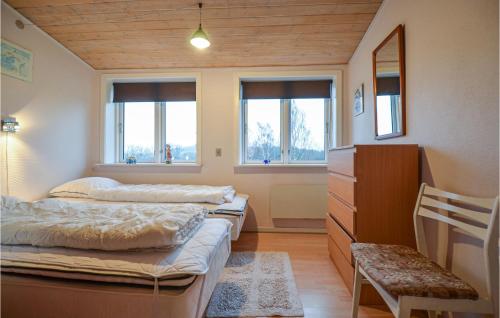 エーベルトフトにあるBeautiful Apartment In Ebeltoft With Kitchenのベッド2台、椅子、窓が備わる客室です。