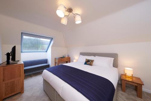 um quarto com uma cama grande e uma televisão em Woodlands Bed & Breakfast em Drumnadrochit