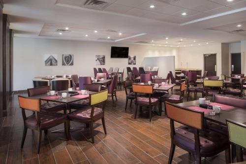a restaurant with tables and chairs in a room at Crowne Plaza Chicago SW - Burr Ridge by IHG in Burr Ridge