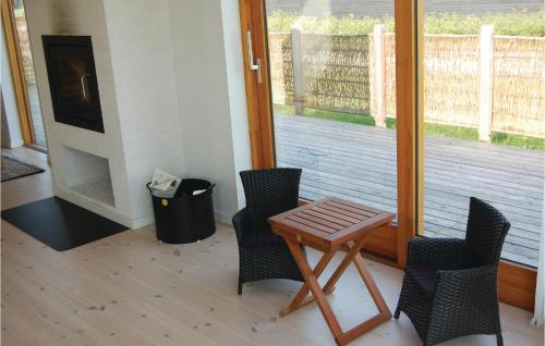 a porch with two chairs and a wooden table and a door at Holiday Home Kongsnæsparken Iv in Stubbekøbing
