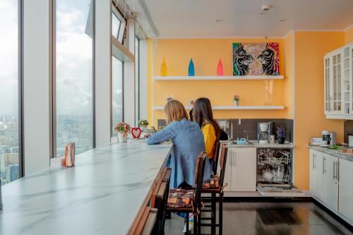 Duas mulheres estão ao balcão na cozinha. em High Level - has a great history, quiet calm and cozy place for only 24 guests! em Moscovo