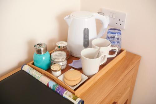 a wooden shelf with a tea pot and cups on it at Woodlands Bed & Breakfast in Drumnadrochit