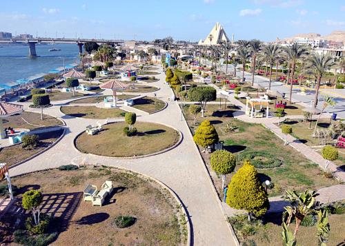 a city street with trees and buildings and the water at Elminya Compound in Al Minya