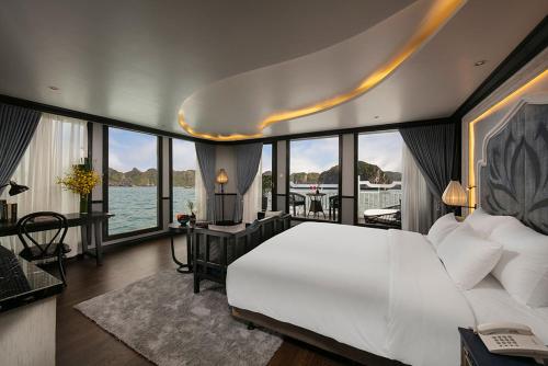sypialnia z dużym białym łóżkiem i widokiem na wodę w obiekcie Madeline Cruises w Ha Long