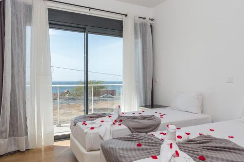 プライアにあるApartHotel Cesaria Beachのベッドが2つと大きな窓がある寝室