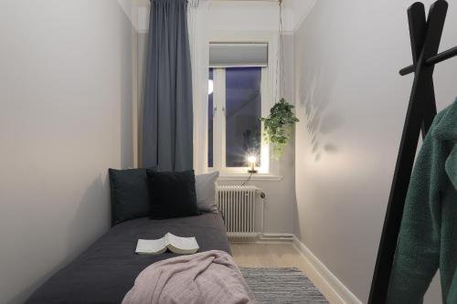 Una habitación pequeña con una cama con zapatos. en Linne Apartment en Uppsala