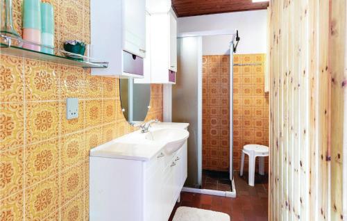 uma casa de banho com um lavatório branco e um WC. em 2 Bedroom Pet Friendly Home In Nex em Bedegård