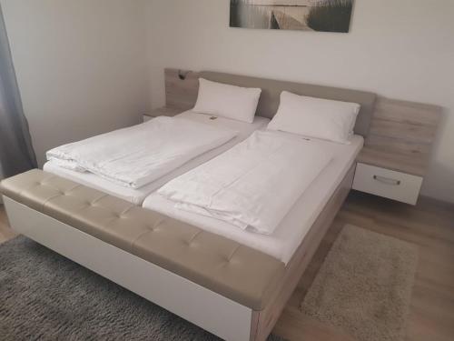 a bed with white sheets and pillows in a room at Pension Hofer in Bad Berneck im Fichtelgebirge