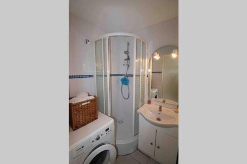 une salle de bain blanche avec une douche et un lavabo dans l'établissement Les Capitelles Bord de plage avec grande piscine - Vue montagne, à Saint-Cyprien