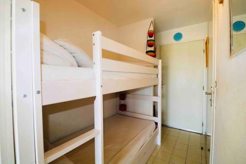 une chambre avec deux lits superposés dans une pièce dans l'établissement Les Capitelles Bord de plage avec grande piscine - Vue montagne, à Saint-Cyprien