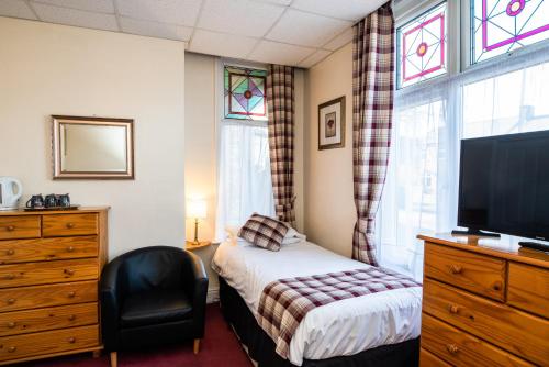 a bedroom with a bed and a tv and a window at The Causeway Guest House in March