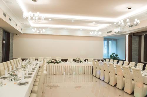 Semič的住宿－HOTEL SMUK，宴会厅配有白色的桌椅