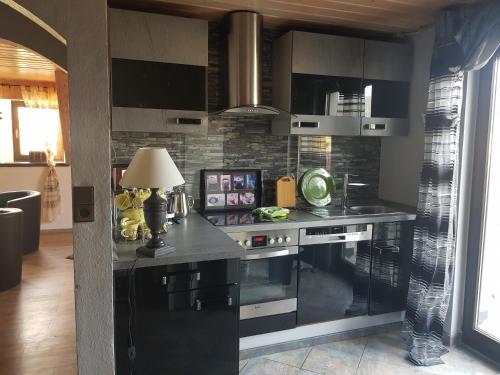 a kitchen with a black counter and a stove at Ferienwohnung Parkblick Medebach in Medebach
