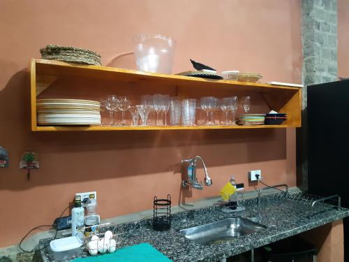 een keuken met een wastafel en een aanrecht met glazen bij Solar corcovado in Ubatuba