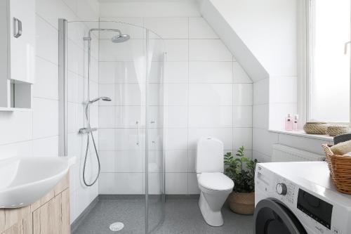 a bathroom with a shower with a toilet and a sink at Linne Studio in Uppsala