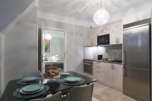 a kitchen with a table and chairs and a refrigerator at Linne Studio in Uppsala