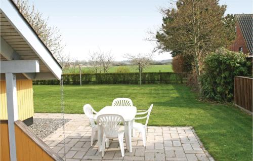 a patio with a white table and chairs in a yard at Gnilbo in Bogense