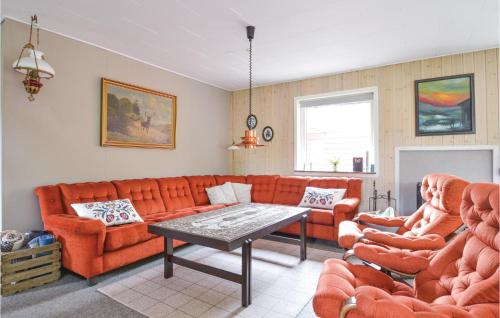 a living room with orange couches and a table at Fjordens Perle in Farsø