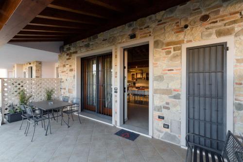 een patio met een tafel en stoelen en een stenen muur bij Casa Lorena in Desenzano del Garda