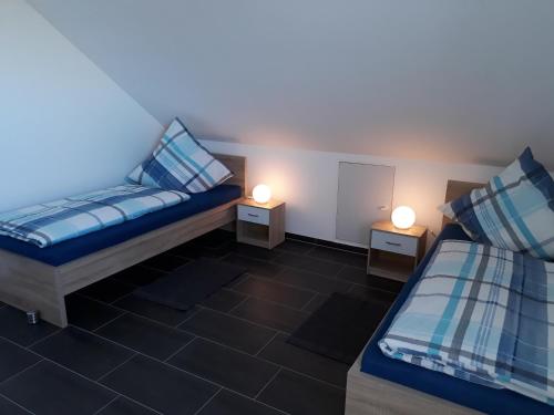 a room with two beds and two lamps on tables at Ferienwohnung Pusteblume in Alpen