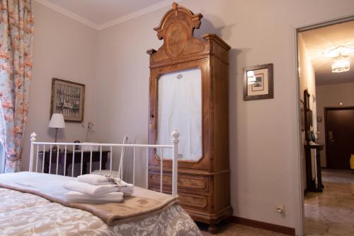 a bedroom with a bed and a large wooden cabinet at Appartamento Santa Rita in Vigevano