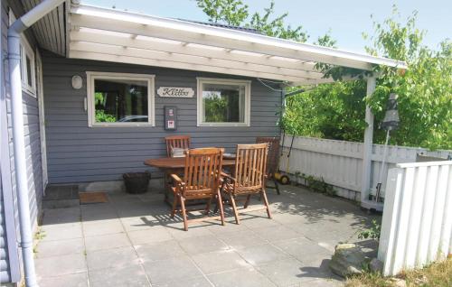 a patio with a table and chairs and a white pergola at Klitbo in Balke