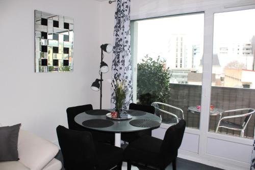 a living room with a table and chairs and a window at Nice flat near Paris MCP in Joinville-le-Pont