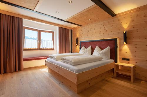 ein Schlafzimmer mit einem Bett in einem Zimmer mit Holzwänden in der Unterkunft Hotel Hauserwirt in Münster