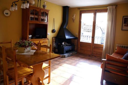 ein Wohnzimmer mit einem Tisch und einem Kamin in der Unterkunft Can Janpere I in Pardines