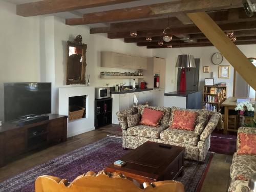 a living room with a couch and a tv at Former Rembrandt workshop two bedroom B&B in Amsterdam