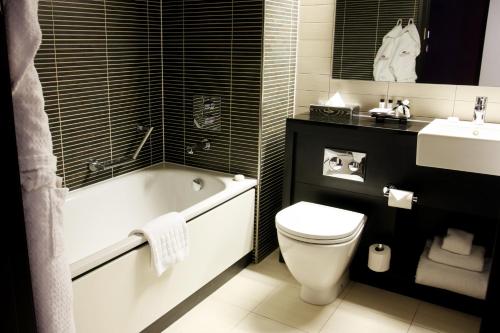 a bathroom with a tub and a toilet and a sink at Crowne Plaza Birmingham City by IHG in Birmingham