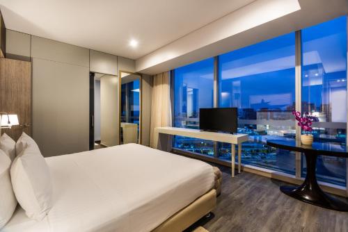 a bedroom with a bed and a desk with a television at Crowne Plaza Barranquilla by IHG in Barranquilla