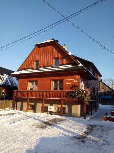 um grande edifício de madeira com neve no chão em Drevenica MAK Oliver em Kvačany